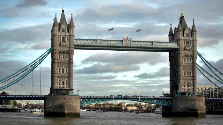 Tower Bridge on Thames river, blue cloudy sky in background in London, England.